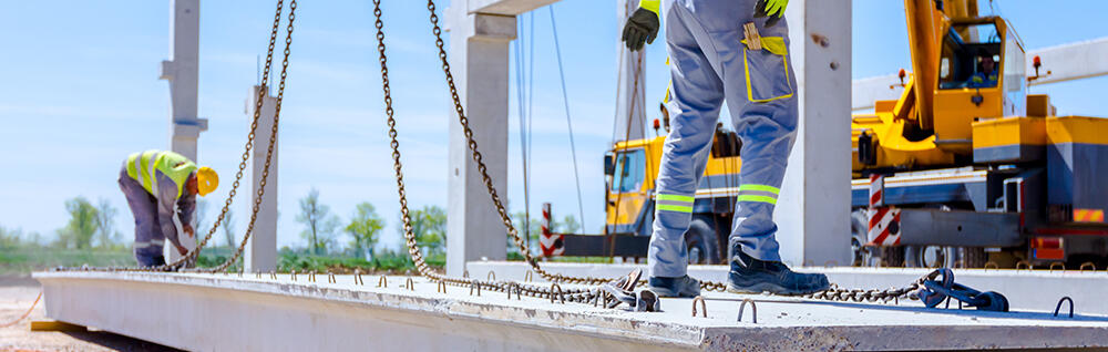 Construction workers attaching crane hooks
