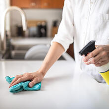 Person cleaning kitchen countertop