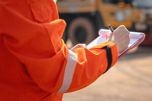 An operation supervisor writing on paper