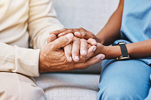 Health care worker and patient holding hands