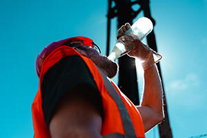 A construction worker drinking water
