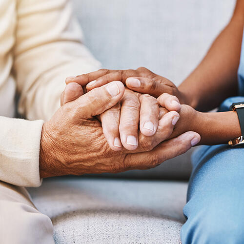 Health care worker and patient holding hands