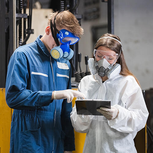 Workers wearing chemical protective mask and hazmat suit
