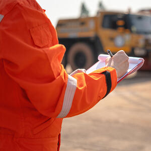 An operation supervisor writing on paper