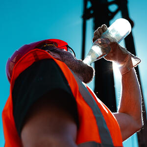 A construction worker drinking water